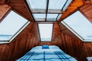 łóżko w pokoju z 4 oknami w obiekcie Sky sighting Iglúhús - Stay'in Árbakki w mieście Litli-Árskógssandur