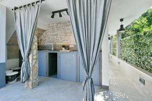 eine Küche mit blauen Vorhängen in einem Haus in der Unterkunft Pikarin rooms in Vrsar