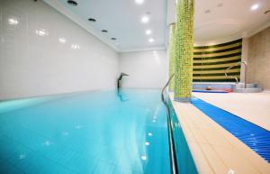 a pool with a swimmer in a swimming pool at Bursztyn Resort in Kołobrzeg +10 photos