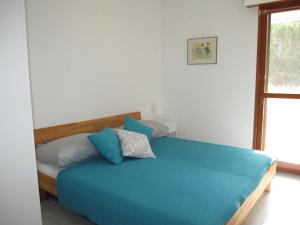 a bedroom with a bed with blue sheets and a window at Appartamento Brubelpi in Lido