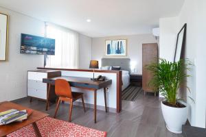 ein Hotelzimmer mit einem Schreibtisch, einem Bett und einem Schlafzimmer in der Unterkunft Arboleda 5 in Silao