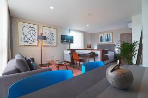uma sala de estar com um sofá e uma mesa com cadeiras azuis em Arboleda 5 em Silao