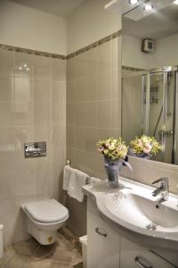 a bathroom with a toilet and a sink with a vase of flowers at Casa la Pianca in Menaggio