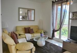 a living room with a yellow couch and a table at Casa la Pianca in Menaggio