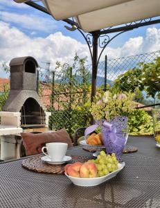 a table with a plate of fruit and a bowl of grapes at Casa la Pianca in Menaggio