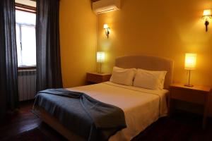 a bedroom with a bed with two lamps and a window at Alojamento Santa Clara in Manteigas
