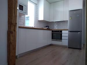 a kitchen with white cabinets and a stainless steel refrigerator at Great apartment with excellent location (Calle Fuencarral/Gran Via/Chueca) in Madrid