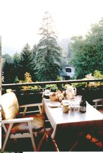 uma mesa branca e cadeiras numa varanda com árvores em Ferienwohnung Ferber em Badenweiler