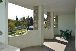 Cette maison blanche dispose d'une terrasse couverte avec une table et des chaises. dans l'établissement Royal Telavi, à Telavi