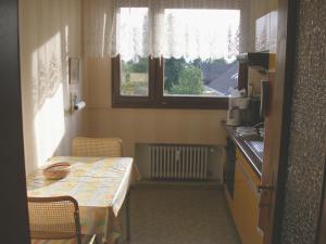 uma pequena cozinha com uma mesa e uma janela em Ferienwohnung Ferber em Badenweiler