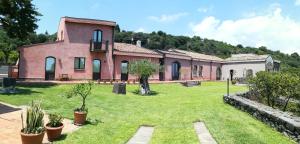 an exterior view of a house with a yard at Il Giardino degli Ovali in Fiumefreddo di Sicilia