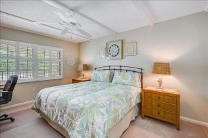 a bedroom with a bed and a desk and a chair at Sea Oats 236 Apartment in Boca Grande
