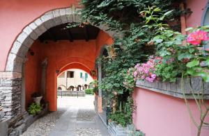 an archway with flowers on a pink building at Ca' De' Mumi in Luino
