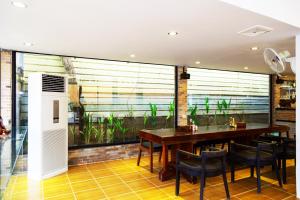 a dining room with a large window with plants at Blossoming Romduol Boutique in Siem Reap