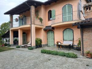 a large house with green doors and a patio at Suite Villa Aurelj in Barolo