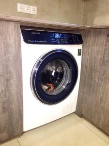 a white washing machine in a corner of a room at Hotel NADIKVARI in Tbilisi City