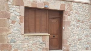 un edificio con puerta de madera y pared de piedra en Apartamento Palacio Azcárate Marisa Sanchez, en Ezcaray