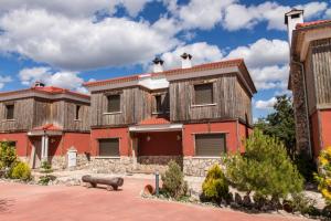 una casa antigua con un edificio rojo en cabañas rurales el hosquillo, en Cuenca