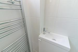 a white bathroom with a sink and a mirror at Hillcrest Lodge in Stevenage