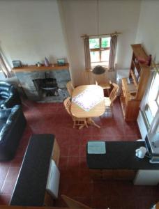 a living room with a couch and a table and a fireplace at Groff Cottage in Toormakeady