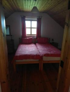 uma cama grande num quarto com uma janela em Groff Cottage em Toormakeady