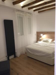 a white bedroom with a bed and a lamp at Great apartment with excellent location (Calle Fuencarral/Gran Via/Chueca) in Madrid