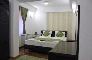 a bedroom with a bed with a window and a mirror at Hotel Fontana in Zenica