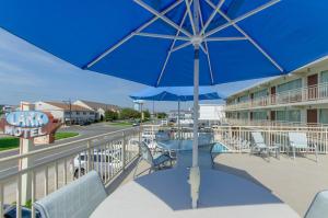 uma mesa e cadeiras com um guarda-sol numa varanda em Lark Motel em Stone Harbor