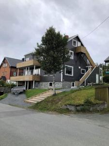 a large house with a tree in front of it at Glass roof private loft in Tromsø in Tromsø +4 photos