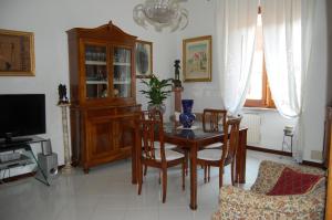 ein Esszimmer mit einem Tisch, Stühlen und einem TV in der Unterkunft B&B Sessoriana in Rom