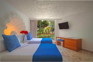 Habitación de hotel con 2 camas, escritorio y ventana en Park Royal Beach Acapulco - All Inclusive en Acapulco