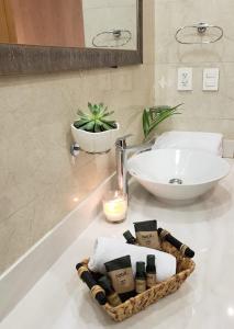 un baño con lavabo y una cesta de toallas en una encimera. en Luxury 5th Avenue Menesse 32 en Playa del Carmen
