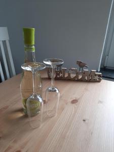 eine Flasche Wein und zwei Gläser auf dem Tisch in der Unterkunft Steuerbord in Wangerland