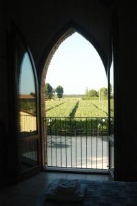een open deur naar een poort met uitzicht op een veld bij Locanda Merlaschio in Faenza