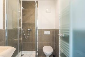a bathroom with a toilet and a glass shower at T11-Appartements & Boardinghouse in Villingen-Schwenningen