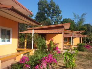 a house with pink flowers in front of it at Tungngoen Resort in Ban Som Poi