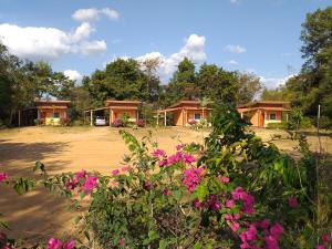a group of cottages with pink flowers in the foreground at Tungngoen Resort in Ban Som Poi