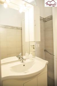 a bathroom with a white sink and a mirror at B & B Raffaello in Terzigno
