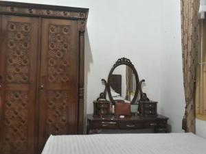 a bedroom with a bed and a dresser and a mirror at BUMiMi HOMESTAY in Painan
