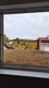 a window view of a field with a red barn at Ferienwohnung Kohl'sche Hof in Juhöhe