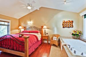 um quarto com uma cama e uma banheira em Bonniebrook Lodge em Gibsons