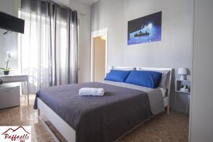 a bedroom with a large bed with blue pillows at B & B Raffaello in Terzigno +17 photos