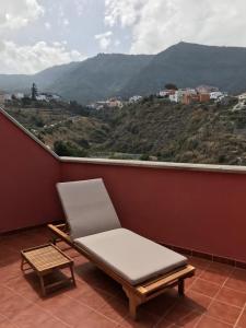 une chaise sur un balcon avec vue sur la montagne dans l'établissement Homeoffice Penthouse vistas panorámicas, à Los Realejos