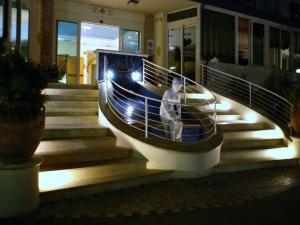 una persona caminando por un conjunto de escaleras con luces en Hotel Lady Mary, en Milano Marittima