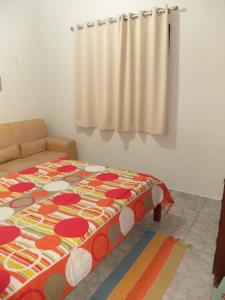 a bedroom with a bed and a curtain at Apto Ubatuba - Toninhas in Ubatuba