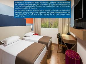 a hotel room with two beds and a desk and a computer at TRYP BY WYNDHAM São Paulo Airport - Hotel de Transito Terminal 3 -Lado Ar - Área restrita á passageiros já embarcados - Piso 1 in Guarulhos