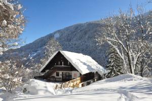 a house covered in snow in front of a mountain at La Grange Aux Loups in Queige