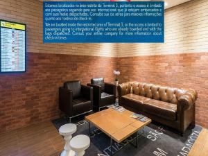 a waiting room with a leather couch and a table at TRYP BY WYNDHAM São Paulo Airport - Hotel de Transito Terminal 3 INTERNACIONAL - Lado Ar - Área restrita á passageiros já embarcados e sem bagagens para despachar - Transit Hotel, only carry-on in Guarulhos