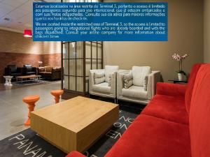 a living room with a red couch and a coffee table at TRYP BY WYNDHAM São Paulo Airport - Hotel de Transito Terminal 3 INTERNACIONAL - Lado Ar - Área restrita á passageiros já embarcados e sem bagagens para despachar - Transit Hotel, only carry-on in Guarulhos