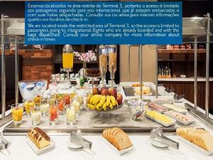 a breakfast buffet with bread and fruit on a table at TRYP BY WYNDHAM São Paulo Airport - Hotel de Transito Terminal 3 INTERNACIONAL - Lado Ar - Área restrita á passageiros já embarcados e sem bagagens para despachar - Transit Hotel, only carry-on in Guarulhos